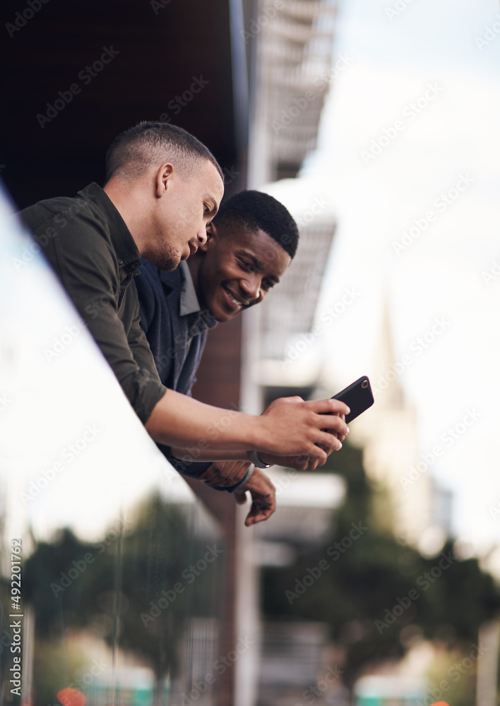 Poster have you seen this. shot of two businessman looking at something on a cellphone while standing on th