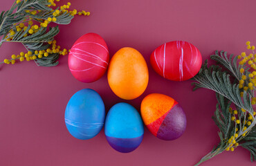 Easter eggs. Festive decoration. Easter. Celebration. Bright holiday. Eggs on a red background. Multi-colored eggs on a red background.