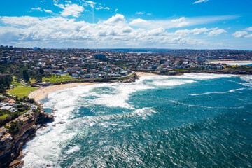 Aerial drone view of iconic Bronte Beach and Tamarama Beach coastline in Sydney, Australia during summer on a sunny day  