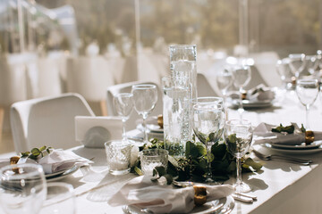 Elegant decoration of a festive wedding table in a restaurant with candles and flowers