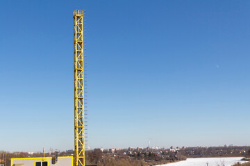A new, yellow, working boiler room outside on a bright sunny day. Modern fuel and environmental pollution.