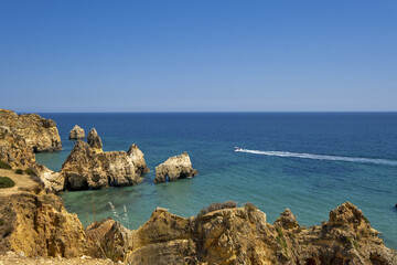 Fototapeta na wymiar the idyllic Praia dos Tres Irmaos Beach surrounded by yellow cliffs and emerald sea in Portimao, Algarve, Portugal