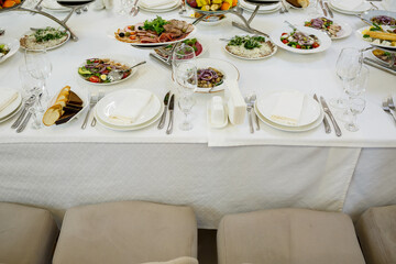 Serving a festive table in a restaurant. Preparation of a banquet for a holiday. Expensive decoration materials. Dishes for food and drinks
