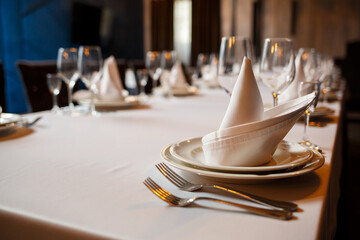 Serving a festive table in a restaurant. Preparation of a banquet for a holiday. Expensive decoration materials. Dishes for food and drinks