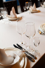 Serving a festive table in a restaurant. Preparation of a banquet for a holiday. Expensive decoration materials. Dishes for food and drinks