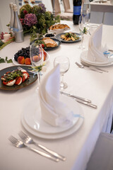 Serving a festive table in a restaurant. Preparation of a banquet for a holiday. Expensive decoration materials. Dishes for food and drinks