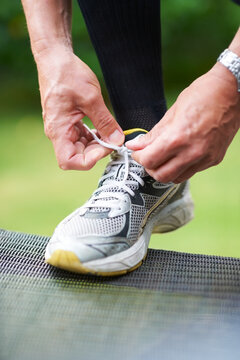 Nothing Worse Than Loose Laces.... Cropped Shot Of A Jogger Resting His Foot On A Chair While Tying His Shoelace.