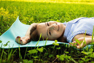 mental health from stress, ptsd, woman in the park lies on the grass smiling