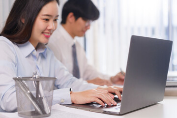 Business concept, Two business colleague checking financial data and typing report on laptop