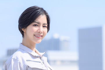 メインビジュアルにも！作業着姿で微笑む日本人女性　カメラ目線