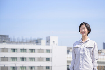 作業着姿で微笑む日本人女性　広角