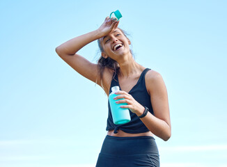 I feel exhausted, but in a good way. Shot of a sporty young woman drinking water while exercising...