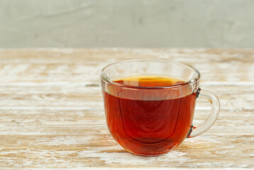 Mug with tea on an old wooden table. Copy space and free space for text near food.