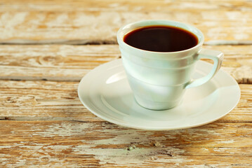 Coffee in a white ceramic mug. Coffee on an old wooden table. Copy space and free space for text near food.