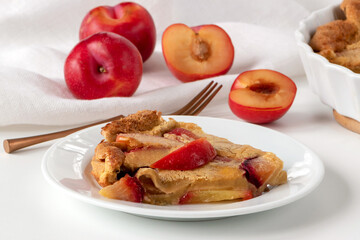 Delicate French dessert clafoutis with plums. Reminiscent a bit of both a pie and a casserole. Plums give it a pleasant sourness.