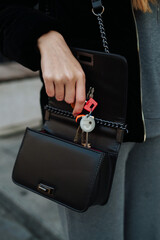 girl puts house keys in black bag