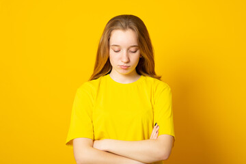Sad teenager girl. Studio image of a cute young girl on yellow background..