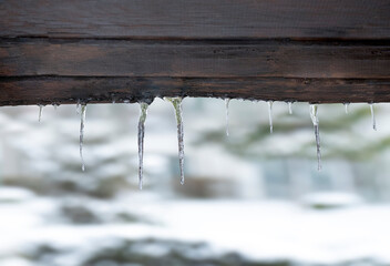 Small icicles on a wooden background.