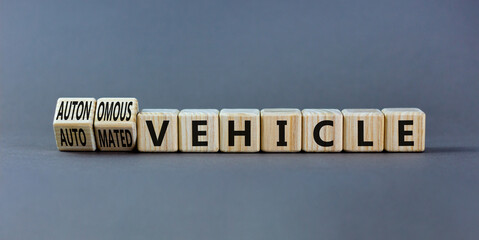 Autonomous or automated vehicle symbol. Turned wooden cubes and changed words Automated vehicle to Autonomous vehicle. Grey background. Business Autonomous or automated vehicle concept, copy space.