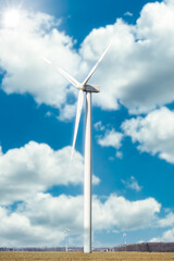 wind turbine in the wind field with clouds and blue sky in the prairie 