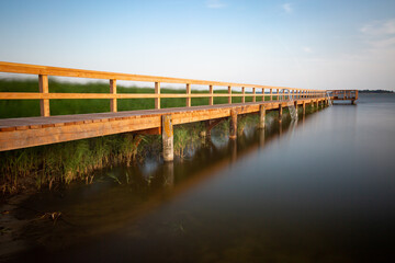 Wooden jetty and reed grass - long exposure