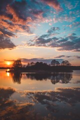 Naklejka na ściany i meble Beautiful morning spring landscape. Sunrise over the lake with a beautiful sky.