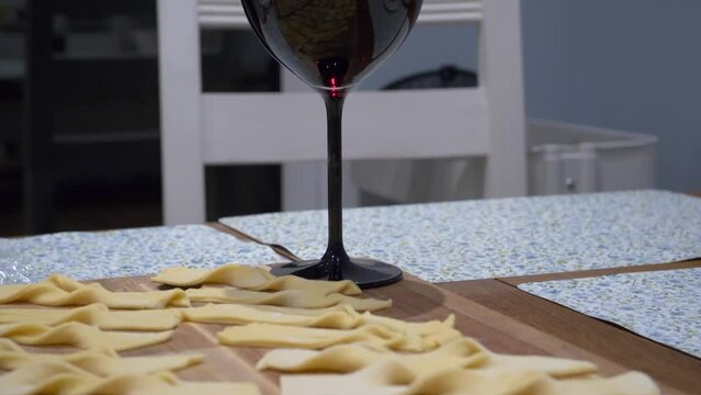 Twisted Faworki Dough On The Table With Glass Of Red Wine On Side. tilt-up reveal