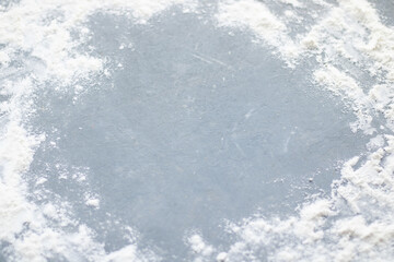 Obraz premium Flour spilling on color background of slate cutting board.