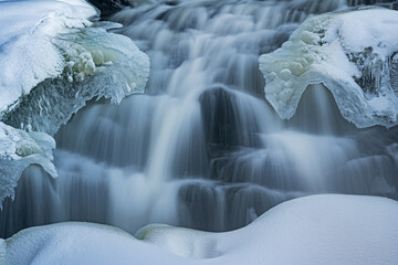 Winter landscape of Bond Falls framed by ice and snow and captured with motion blur, Ottawa...