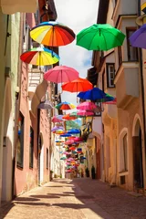 Poster Colored umbrellas decorates alley in old town in Chiusa Italy © woloha79