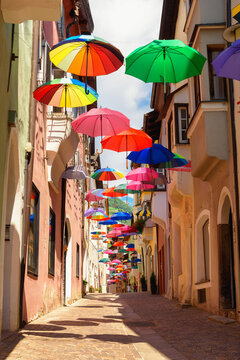 Colored umbrellas decorates alley in old town in Chiusa Italy