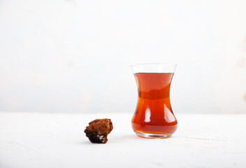 Chaga tea in a Turkish glass on a light background. Healthy food concept. Copy spaes.