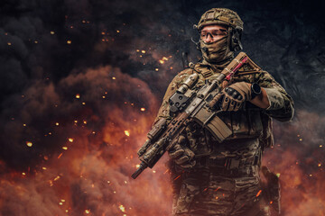Obraz premium Special force soldier with firearm weapon against burning background
