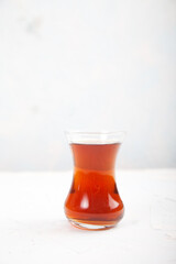 Chaga tea in a Turkish glass on a light background. Healthy food concept. Copy spaes. vertically