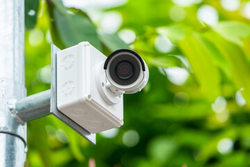 CCTV camera is installed in the garden with blur green tree background for monitor and safety...