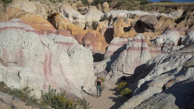 Paint Mines Interpretive State Park, Calhan, Colorado USA. Female Hiker Walking Between Unique Rock Formations on Sunny Day