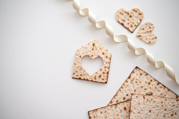 Layout of Matzah shape of small house, hearts and tape on white background. Traditional of Jewish Holiday on Passover. Home symbol of happy family. Purchase or rent. top view. Real Estate Agency