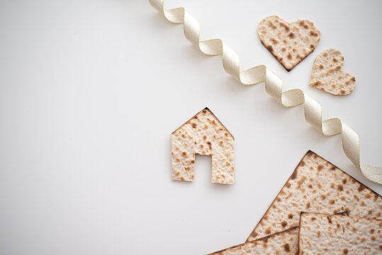 Layout of Matzah shape of small house, hearts and tape on white background. Traditional of Jewish Holiday on Passover. Home symbol of happy family. Purchase or rent. top view. Real Estate Agency