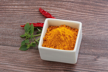 Yellow vibrant curcuma powder in the bowl