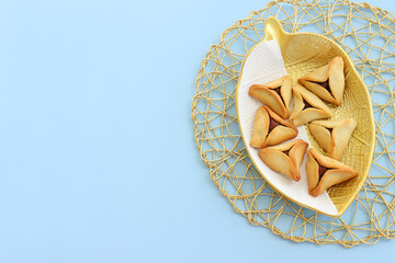 Purim celebration concept (jewish carnival holiday). Hamantaschen cookies over blue pastel background