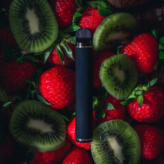 Disposable electronic cigarettes of different flavors over different fruits on the background. The...
