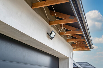The light for the motion sensor mounted on the facade of the building above the garage door in...