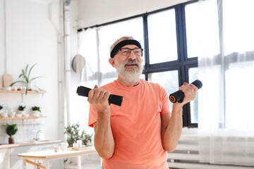 Senior man doing fitness exercise at home with dumbbells - elderly people and wellness health concept