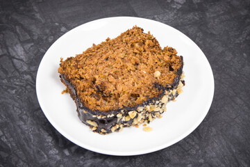 Pastry made of zucchini with nuts and raisin on plate. Delicious dessert