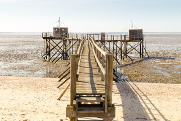 Deux carrelets avec le même accès à marée basse dans une baie très plate en Vendée. Pêcherie des Moutiers en Retz, côte de Jade