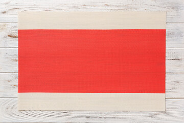 Top view of red tablecloth for food on wooden background. Empty space for your design