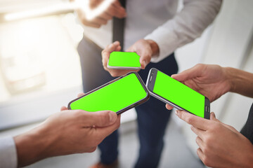 Making things happen in the smart age. Cropped shot of a group of colleagues using their smart phones in synchronicity.