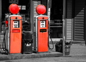 Vintage red gas pumps on a black and white background.