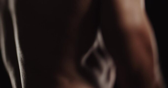 Close up video of topless and handsome guy flexing his muscles, tilt shift