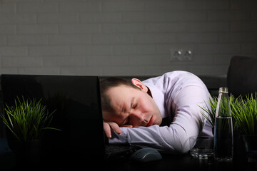 Obraz premium man sitting at table and working on laptop